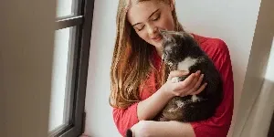 woman holding cat in arms