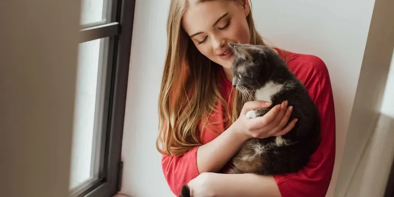 woman holding cat in arms
