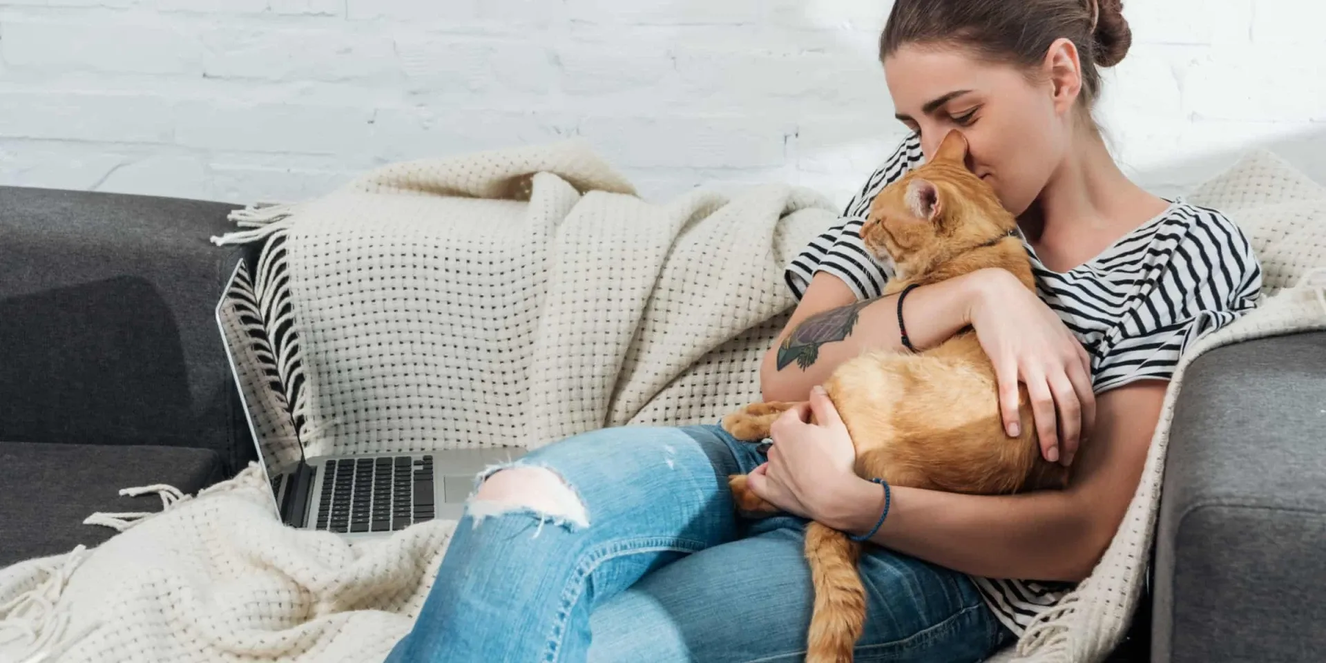 A woman is sitting on a couch with her cat.
