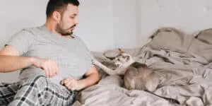 A man laying in bed with a cat.