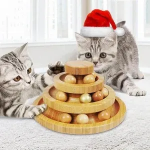 Two cats playing with a wooden toy in a santa hat.